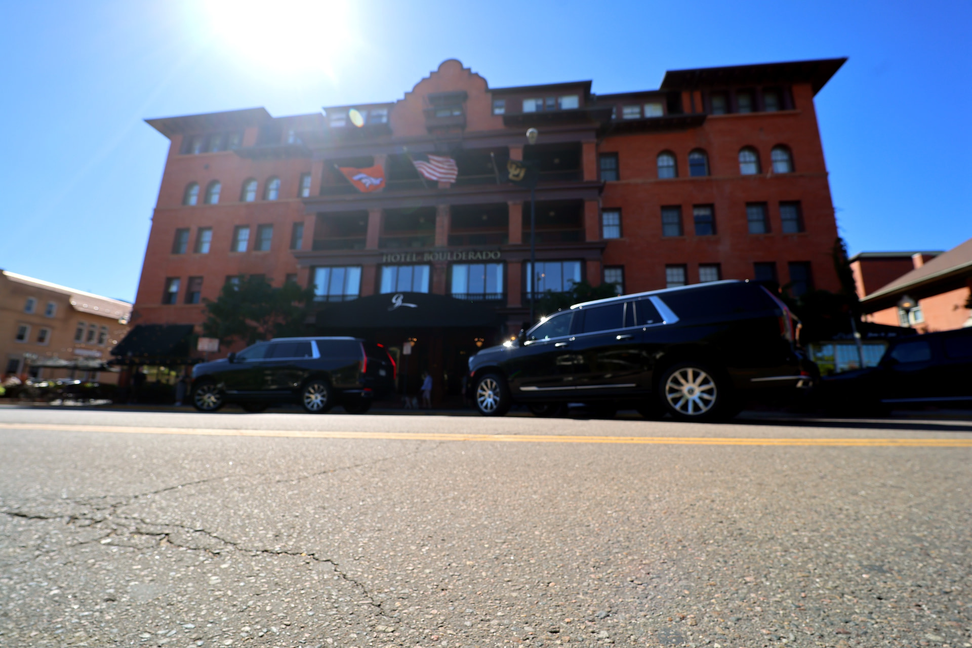 Black executive vehicles outside the Hotel Boulderado in Boulder, Colorado.